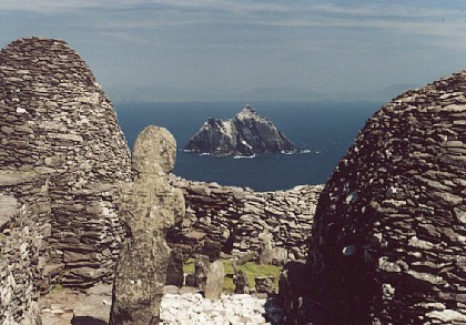 Beehive huts with stone cross and Little Skellig Island
